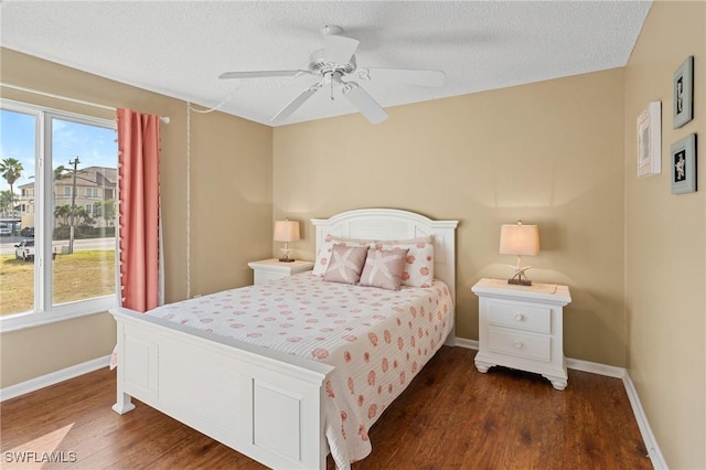 bedroom with ceiling fan, dark hardwood / wood-style flooring, and a textured ceiling