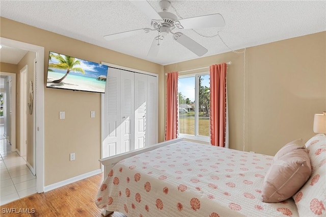 bedroom featuring ceiling fan, a closet, a textured ceiling, and light wood-type flooring