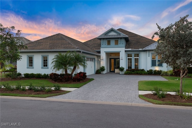 view of front of property with a garage, a yard, and french doors