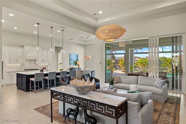 living room featuring light hardwood / wood-style flooring and a tray ceiling