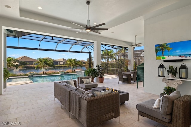 view of patio / terrace featuring outdoor lounge area, glass enclosure, a water view, pool water feature, and ceiling fan