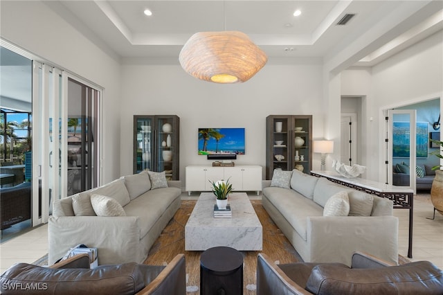 living room with a towering ceiling and a tray ceiling