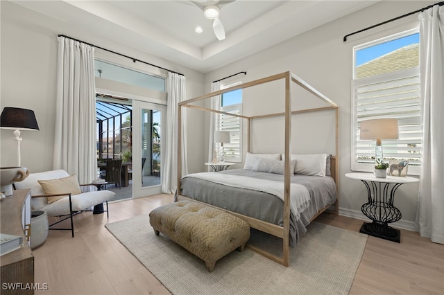 bedroom featuring ceiling fan, light wood-type flooring, access to outside, and french doors