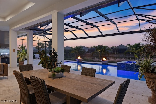 pool at dusk featuring an in ground hot tub, a patio, pool water feature, and a lanai