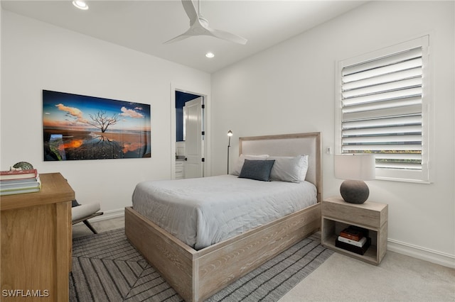 carpeted bedroom featuring ceiling fan and ensuite bathroom