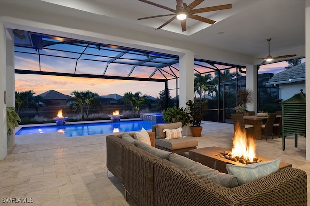 pool at dusk with glass enclosure, ceiling fan, and a patio area