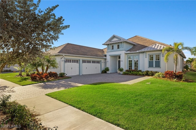 view of front of home with a front yard and a garage