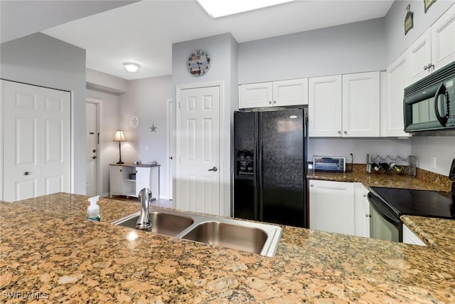 kitchen with black appliances, sink, dark stone countertops, white cabinetry, and kitchen peninsula