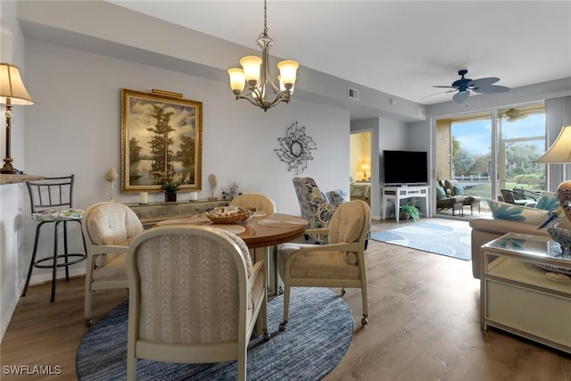 dining room featuring hardwood / wood-style floors and ceiling fan with notable chandelier