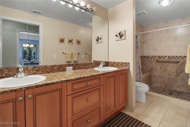 bathroom featuring a shower with shower curtain, vanity, tile patterned flooring, a chandelier, and toilet