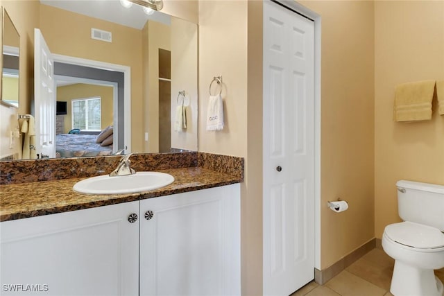 bathroom featuring tile patterned floors, vanity, and toilet