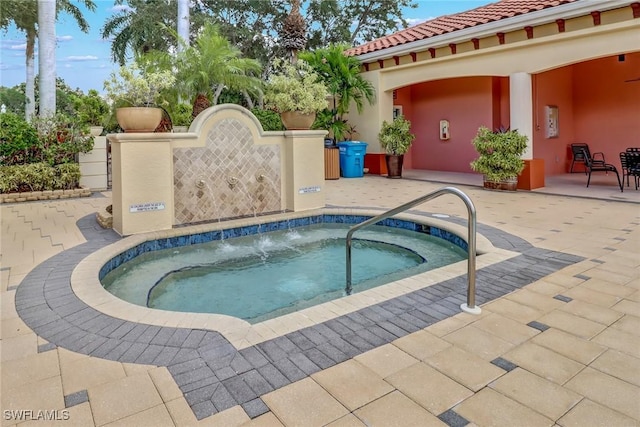 view of pool with a hot tub and a patio area