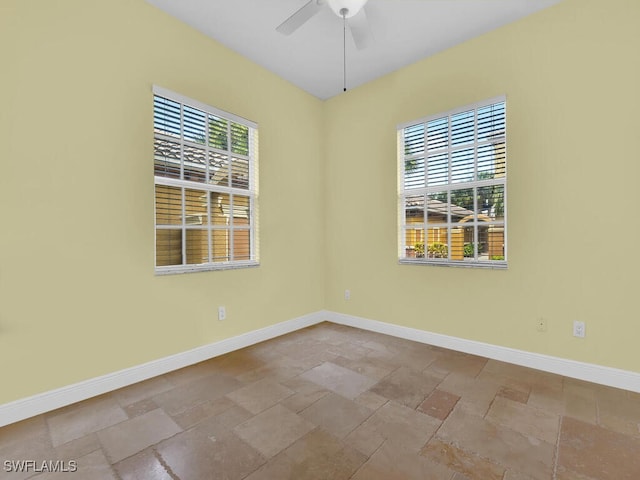 empty room featuring ceiling fan and plenty of natural light