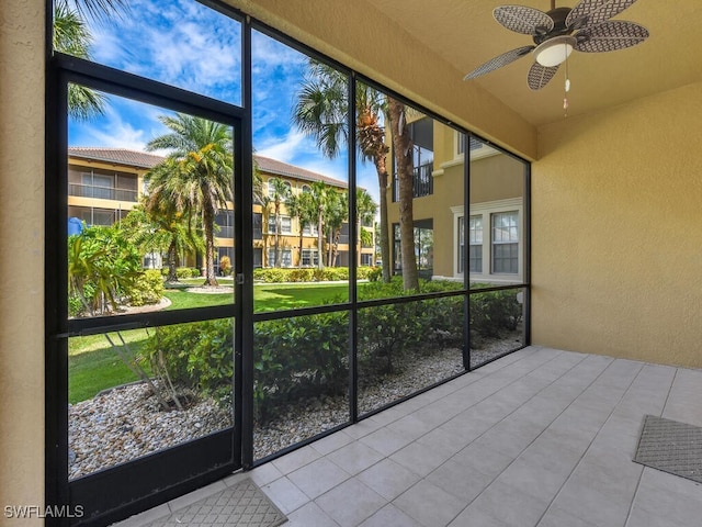 unfurnished sunroom featuring ceiling fan