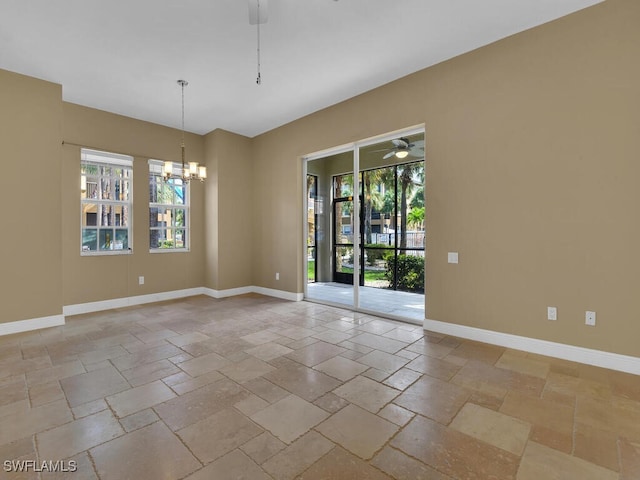 empty room featuring ceiling fan with notable chandelier