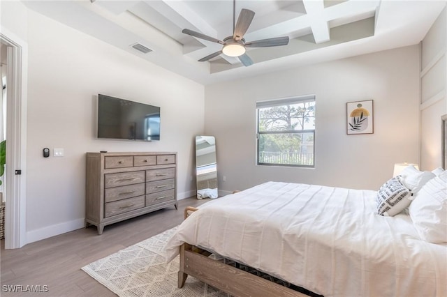 bedroom featuring beam ceiling, ceiling fan, light hardwood / wood-style floors, and coffered ceiling