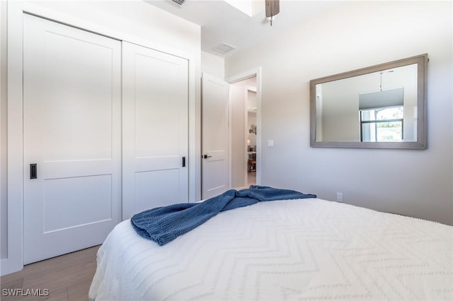 bedroom with light wood-type flooring, a closet, and ceiling fan