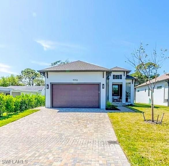 view of front of property featuring a front yard and a garage