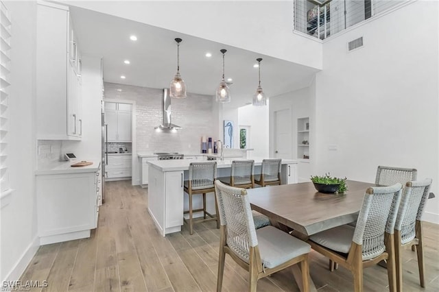 dining room featuring a high ceiling and light wood-type flooring