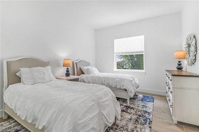 bedroom with light wood finished floors and baseboards