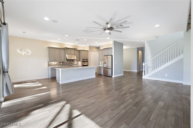 kitchen featuring gray cabinetry, high quality fridge, decorative light fixtures, a kitchen island, and dark hardwood / wood-style flooring