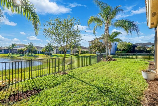 view of yard with a water view, fence, and a residential view