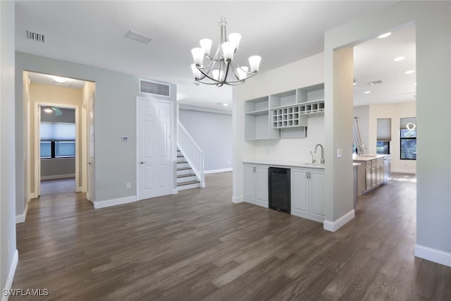 kitchen featuring sink, hanging light fixtures, dark wood-type flooring, wine cooler, and a chandelier