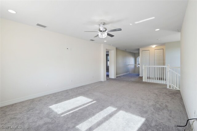 carpeted spare room featuring ceiling fan