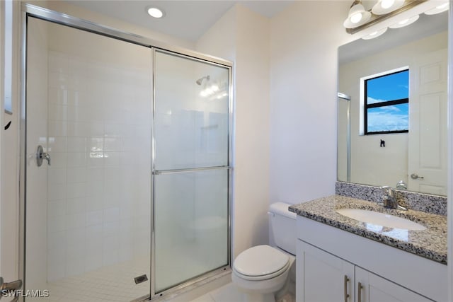 bathroom with vanity, toilet, and a shower with shower door