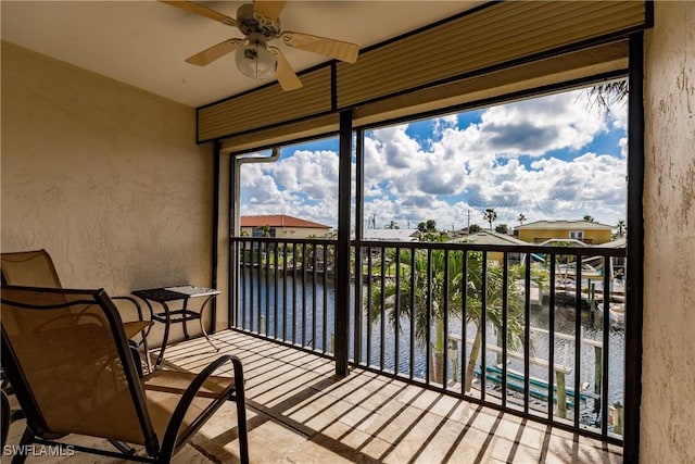 sunroom / solarium featuring ceiling fan, a water view, and plenty of natural light