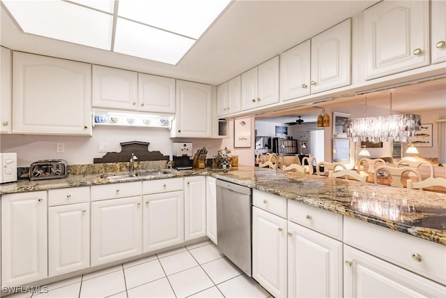 kitchen featuring dishwasher, ceiling fan with notable chandelier, sink, light tile patterned flooring, and white cabinetry