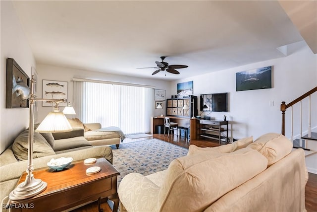 living room featuring ceiling fan and dark wood-type flooring