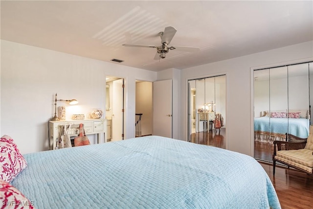 bedroom with dark hardwood / wood-style flooring, ceiling fan, and multiple closets