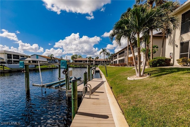 view of dock with a yard and a water view