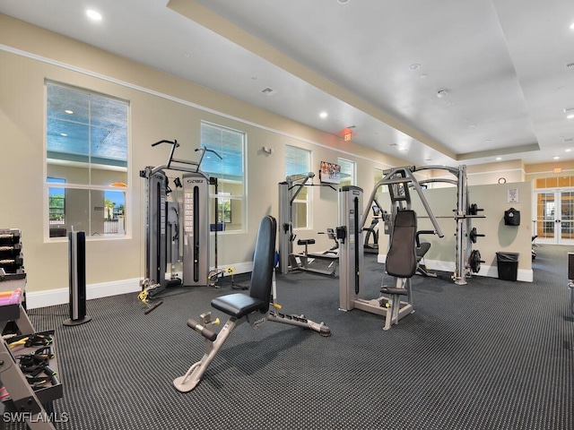 workout area with a tray ceiling