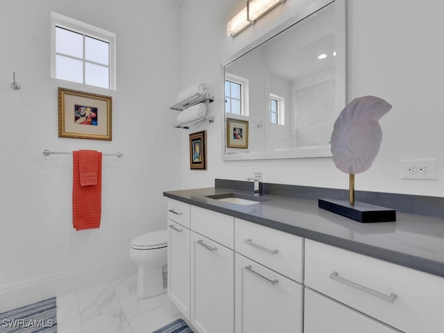 bathroom with vanity, toilet, a shower, and a wealth of natural light