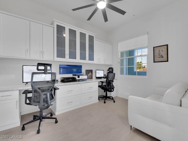 home office with ceiling fan and built in desk