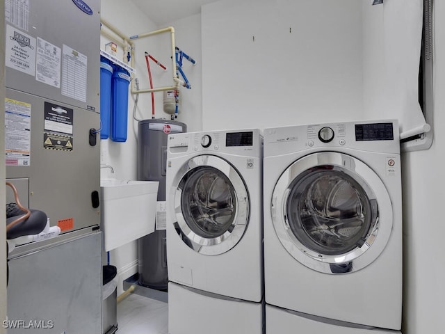 laundry area with washer and clothes dryer, water heater, and heating unit