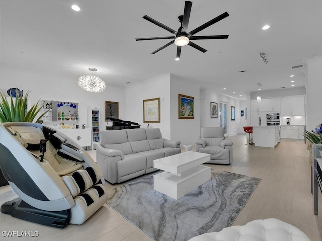 living room featuring ceiling fan with notable chandelier and light hardwood / wood-style floors