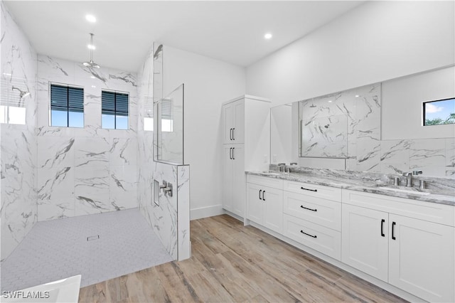 bathroom featuring a tile shower, hardwood / wood-style floors, and vanity