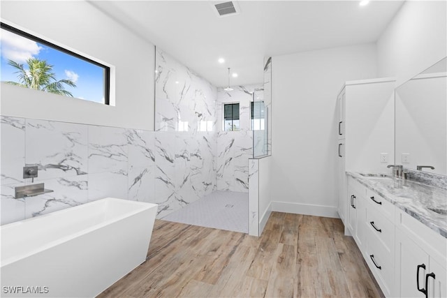 bathroom with vanity, independent shower and bath, and wood-type flooring