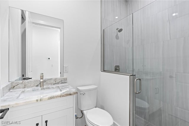 bathroom with an enclosed shower, vanity, and toilet