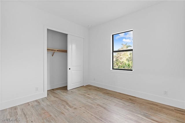 unfurnished bedroom featuring light wood-type flooring and a closet