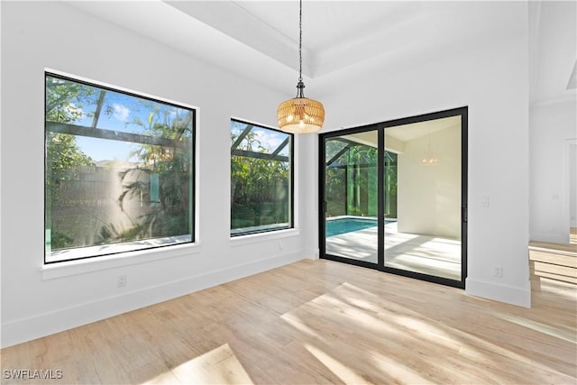 empty room featuring a notable chandelier and light wood-type flooring