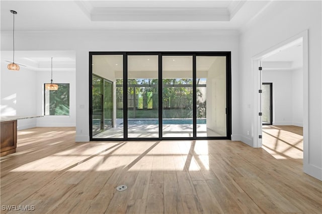 unfurnished room featuring light hardwood / wood-style floors, crown molding, and a tray ceiling