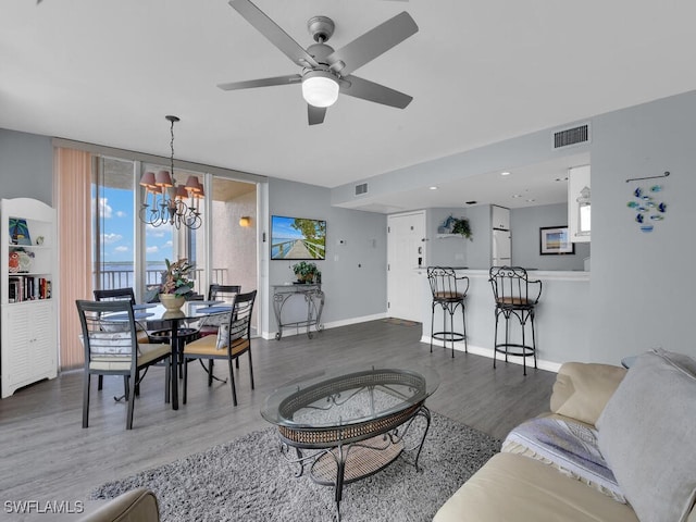 living room with hardwood / wood-style floors and ceiling fan with notable chandelier