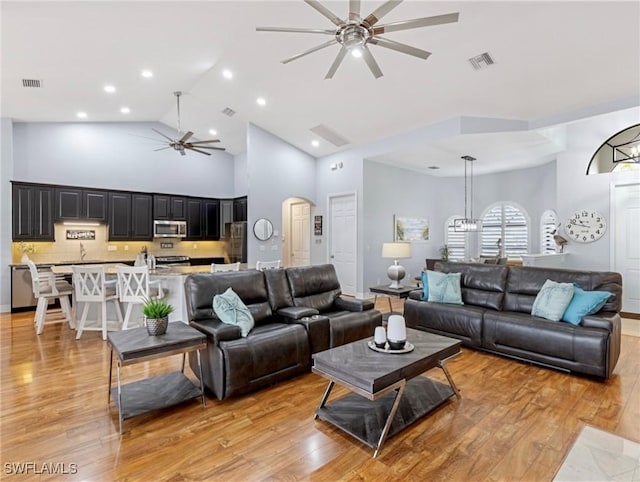 living room featuring ceiling fan, light hardwood / wood-style flooring, and high vaulted ceiling