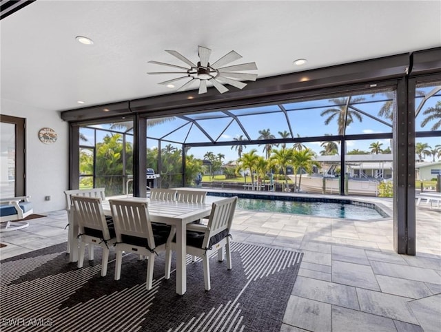 view of patio with ceiling fan and glass enclosure