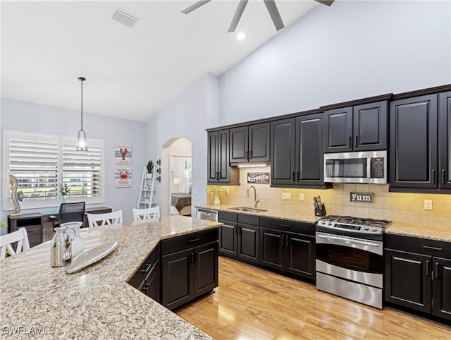 kitchen featuring ceiling fan, sink, pendant lighting, a breakfast bar, and appliances with stainless steel finishes