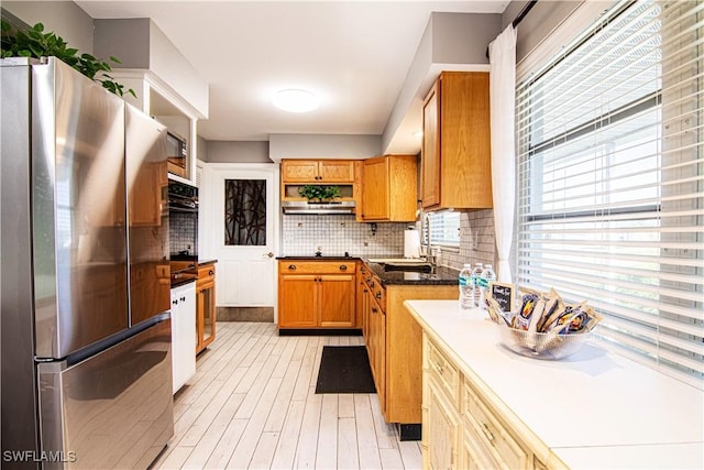 kitchen with sink, stainless steel appliances, and tasteful backsplash